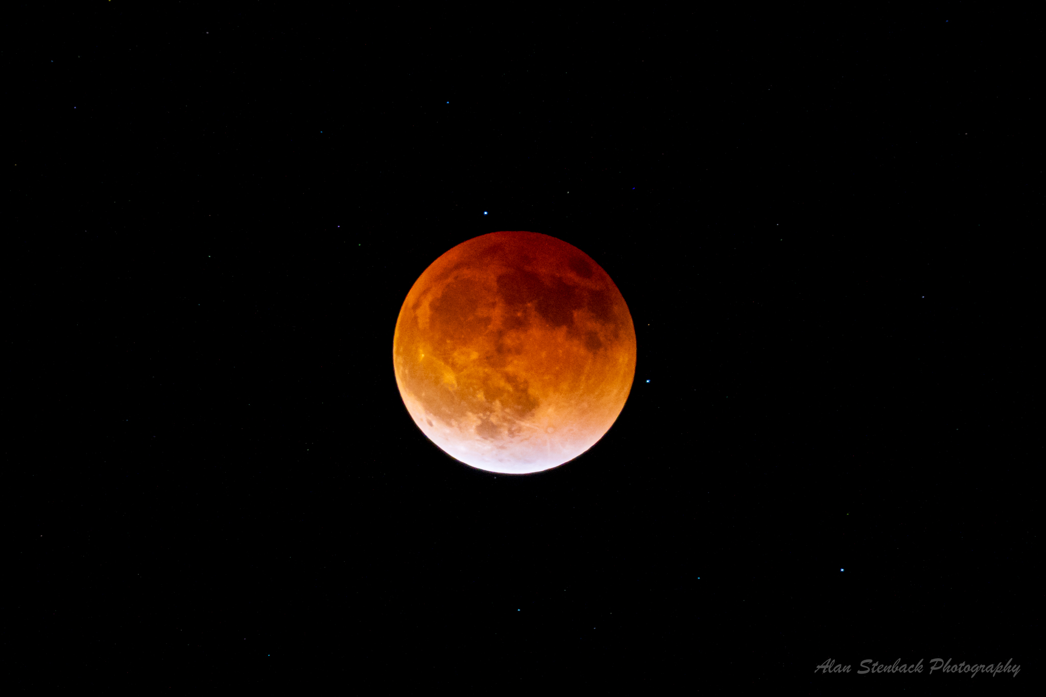 Blood Moon in a starry night sky during a total lunar eclipse.