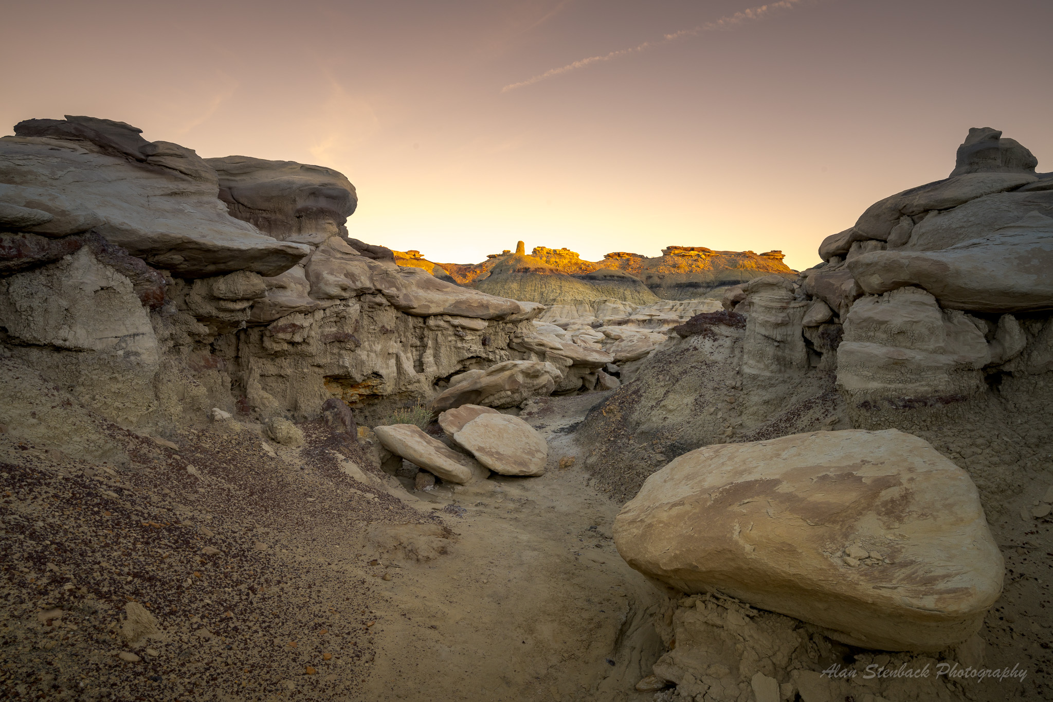 Sunset over Bisti Badlands' unique rock formations and desert landscape in New Mexico.