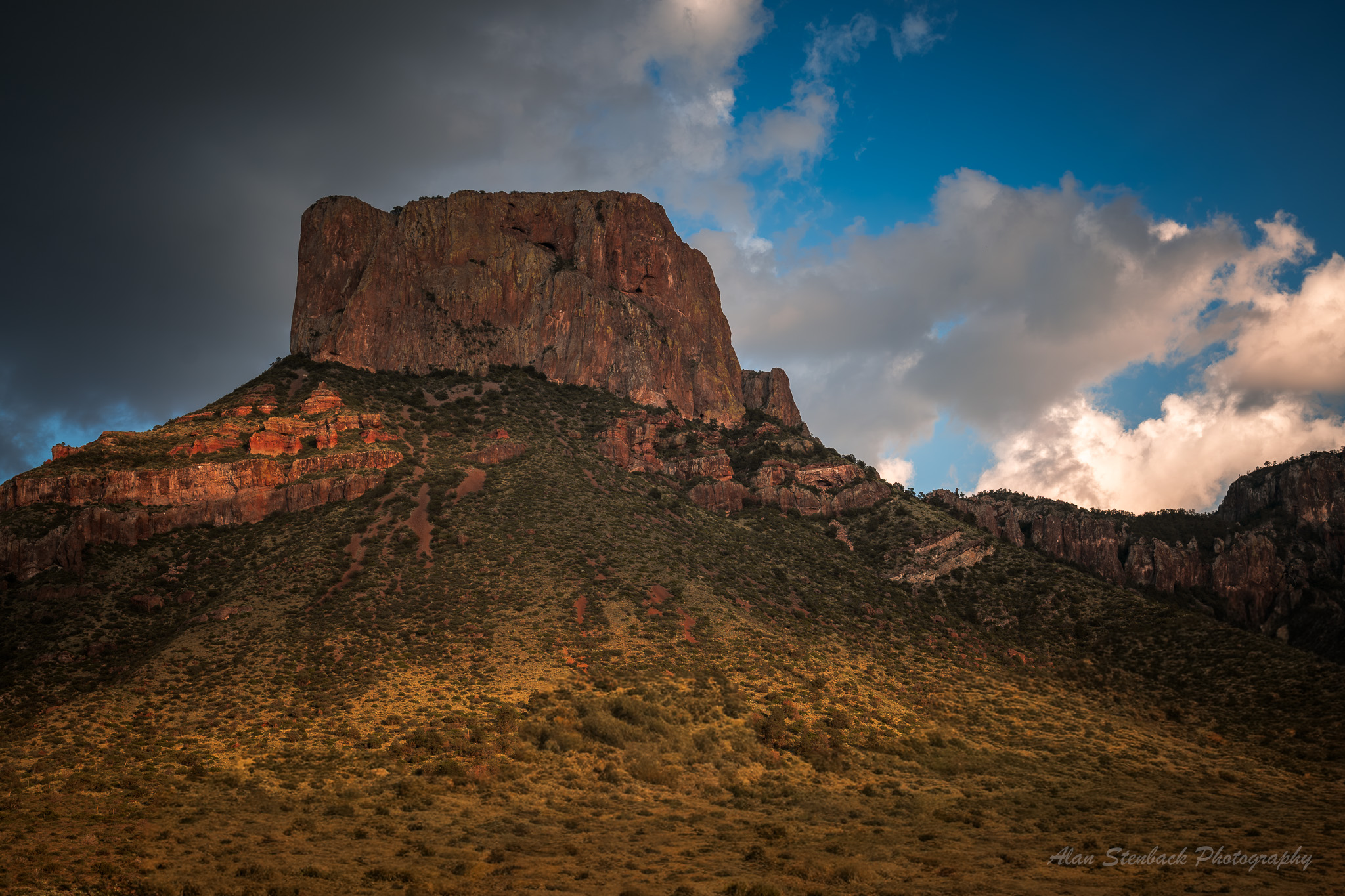 Dramatic mountain landscape at Big Bend National Park with rugged cliffs under partly cloudy sky.