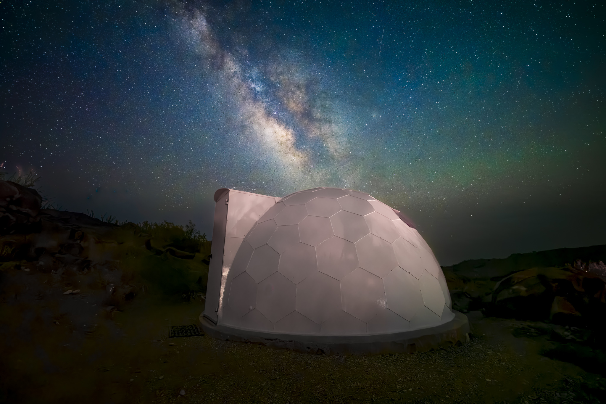 Geodesic dome observatory under the Milky Way galaxy at night.